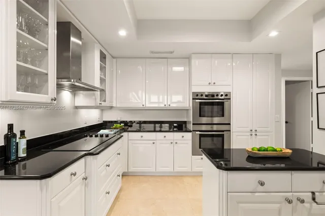 a kitchen with granite countertop a sink a stove and cabinets