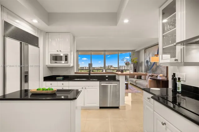 a kitchen with stainless steel appliances granite countertop a sink a stove and a refrigerator