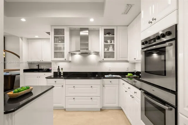 a kitchen with granite countertop a sink stainless steel appliances and cabinets
