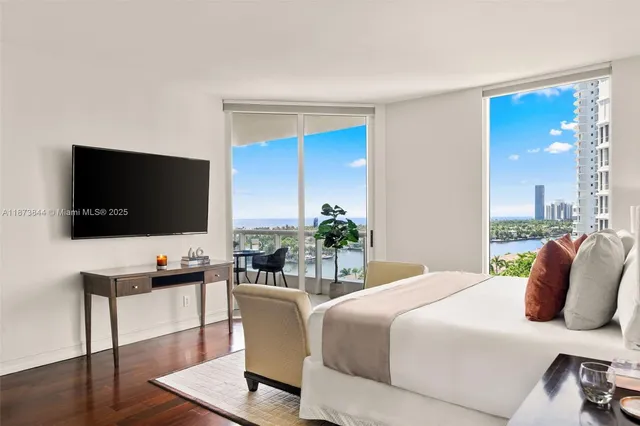 a bedroom with a bed a flat screen tv and a couch