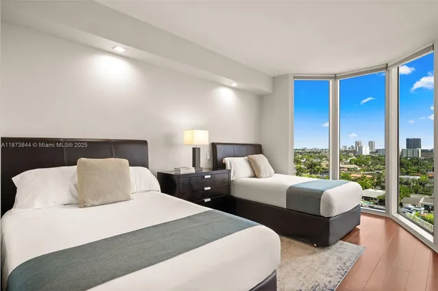 a bedroom with two beds and a large window