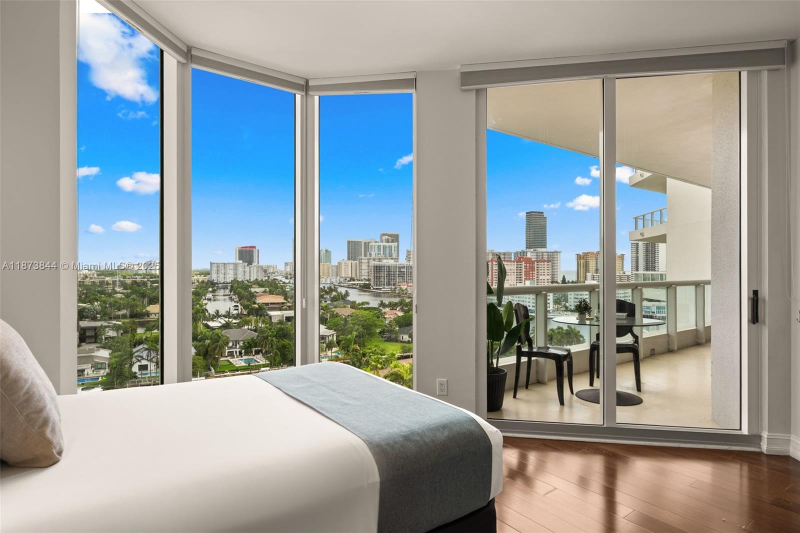 21200 Point Place, Unit 1102 Aventura, FL 33180 - Photo 25 of 41 a bedroom with a large window and a table