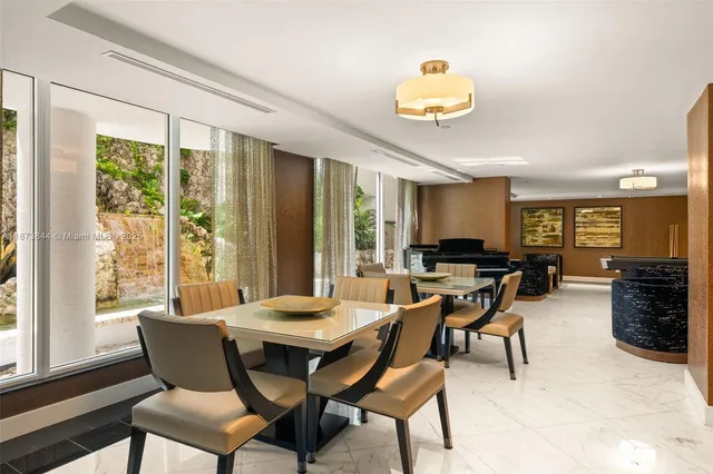 a dining room with furniture a rug and a large window