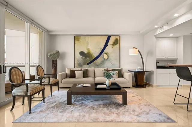 a living room with furniture a large window and a potted plant