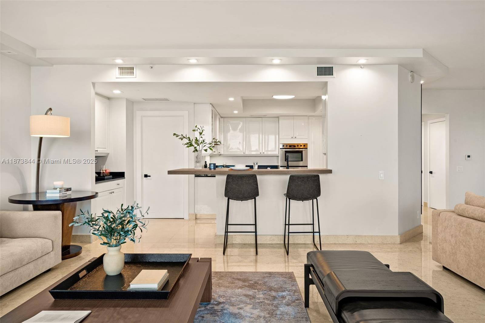 21200 Point Place, Unit 1102 Aventura, FL 33180 - Photo 9 of 41 a living room with furniture and a lamp