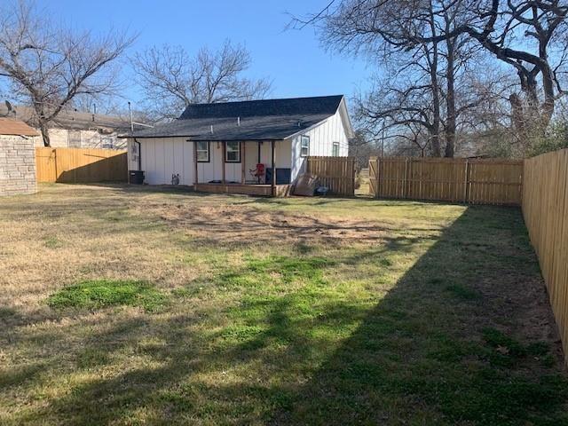 511 East Washington Street Denison, TX 75021 - Photo 11 of 12 Rear view of property featuring a fenced backyard and board and batten siding