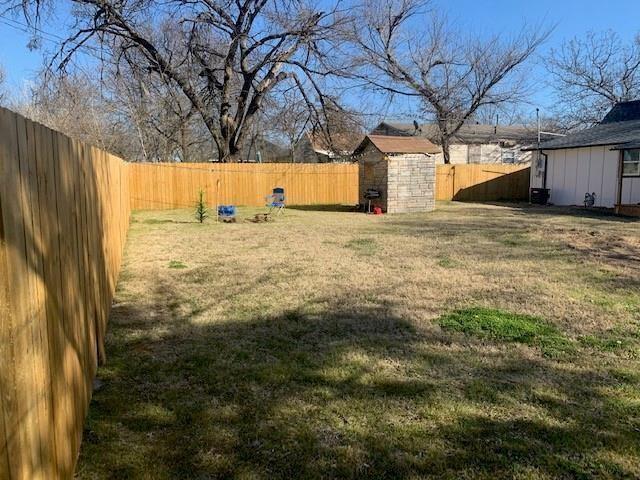 511 East Washington Street Denison, TX 75021 - Photo 12 of 12 Fenced backyard with a storage unit