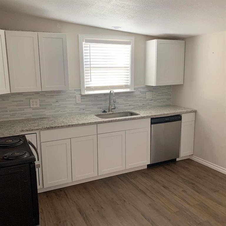 511 East Washington Street Denison, TX 75021 - Photo 2 of 12 Kitchen with black electric range, white cabinetry, a textured ceiling, stainless steel dishwasher, and light stone counters