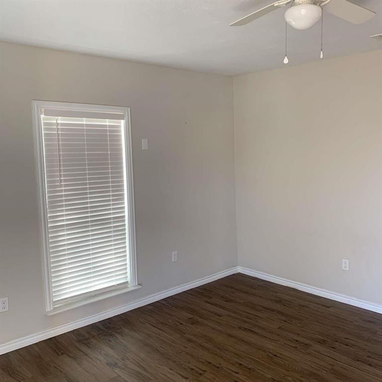 511 East Washington Street Denison, TX 75021 - Photo 5 of 12 Spare room featuring dark wood-type flooring and a ceiling fan