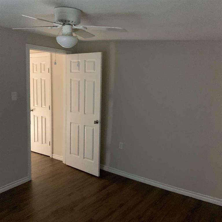 511 East Washington Street Denison, TX 75021 - Photo 6 of 12 Unfurnished bedroom with dark wood-type flooring and ceiling fan