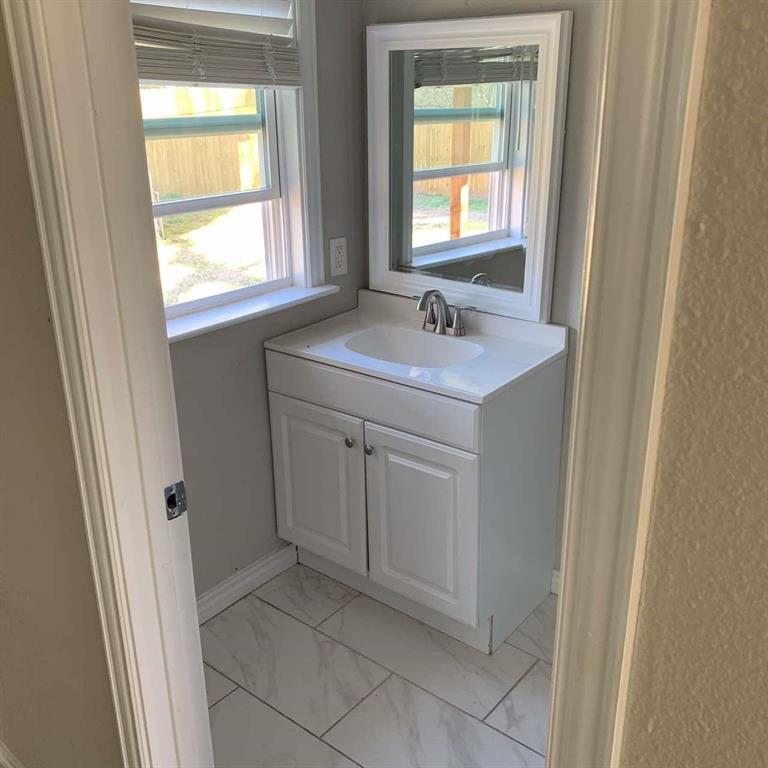 511 East Washington Street Denison, TX 75021 - Photo 7 of 12 Bathroom with vanity and light marble finish floors