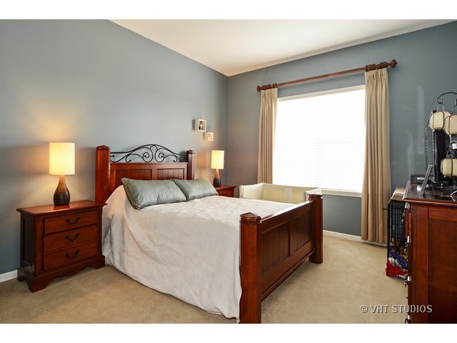 227 Grand Ridge Road, Unit 227 St. Charles, IL 60175 - Photo 5 of 10 a bed sitting in a bedroom next to a window