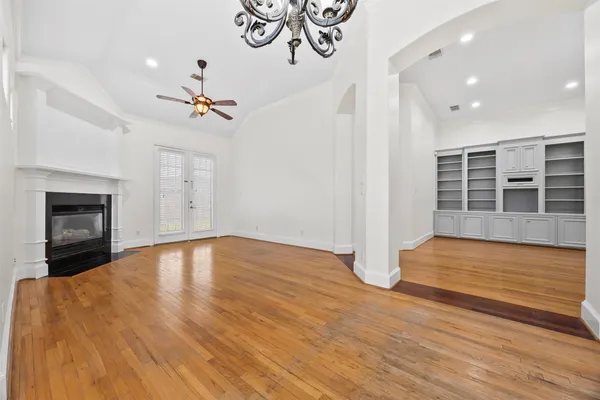 a view of empty room with wooden floor and fireplace