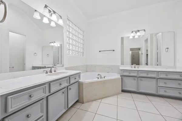 a spacious bathroom with a granite countertop sink mirror and bathtub