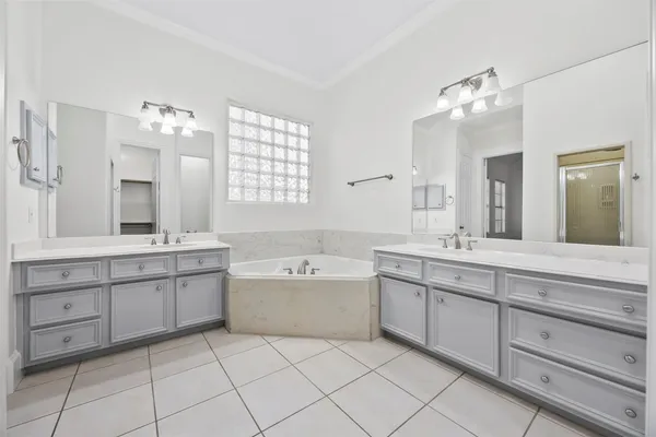 a spacious bathroom with a double vanity sink mirror and bathtub