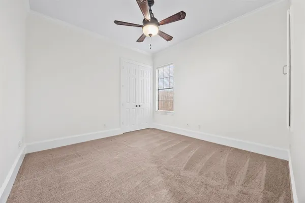 an empty room with a ceiling fan and a window