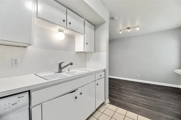 a kitchen with a sink cabinets and wooden floor