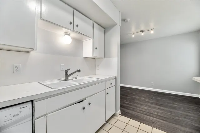 a kitchen with a sink cabinets and wooden floor