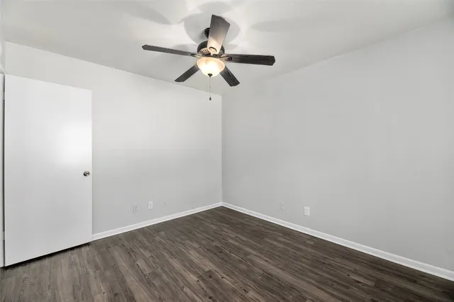 a view of a room with wooden floor and ceiling fan
