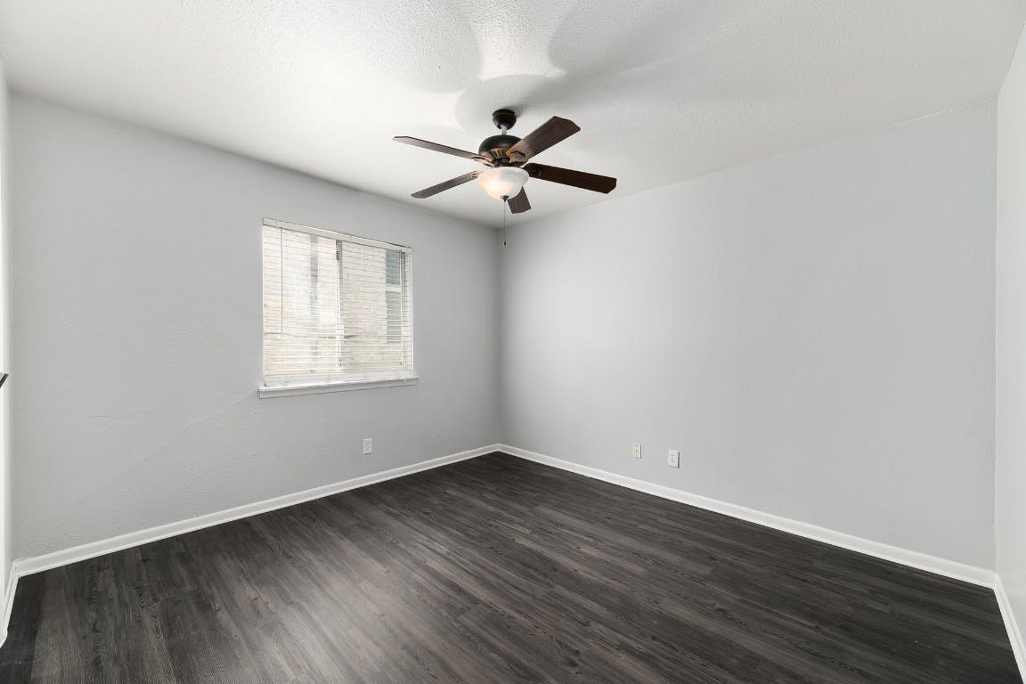 2408 Longview Street, Unit 113 Austin, TX 78705 - Photo 16 of 23 an empty room with wooden floor ceiling fan and windows