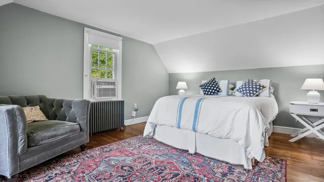 a bedroom with a bed couch and a window