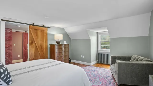 a bedroom with a bed dresser and a window