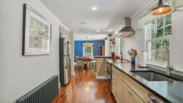 a very nice looking kitchen with granite countertop a large window and stainless steel appliances
