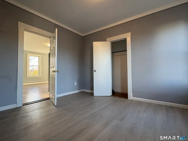 an empty room with wooden floor and closet