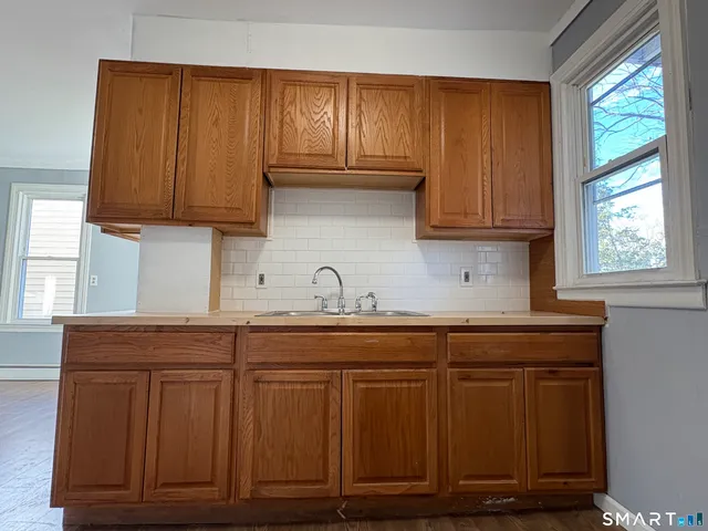 a kitchen with granite countertop wooden cabinets a sink and dishwasher