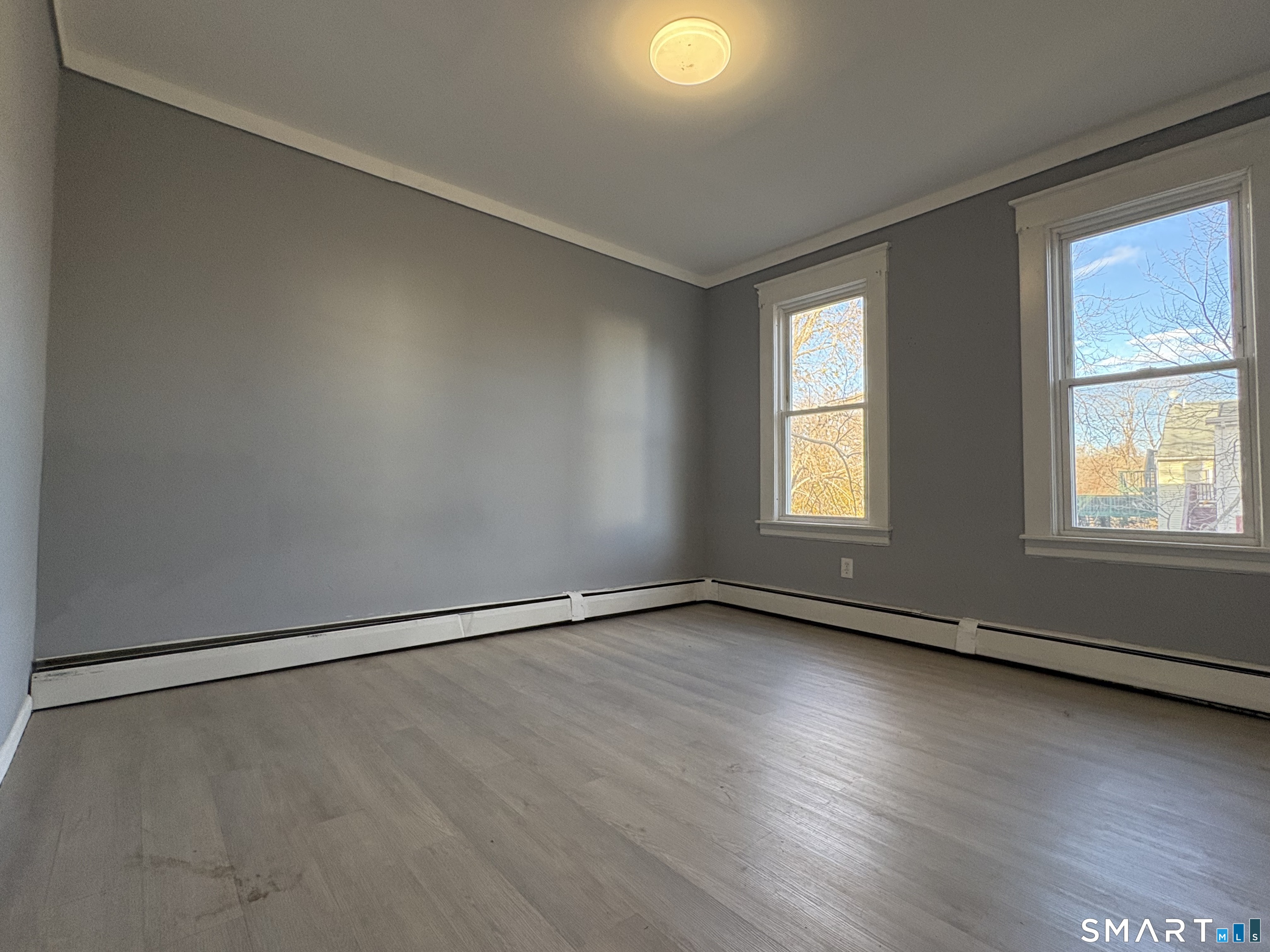 3 Omo Street, Unit 2 Middletown, CT 06457 - Photo 8 of 12 an empty room with wooden floor and windows
