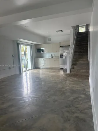 an empty room with wooden floor and entryway