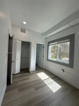 an empty room with windows and closet