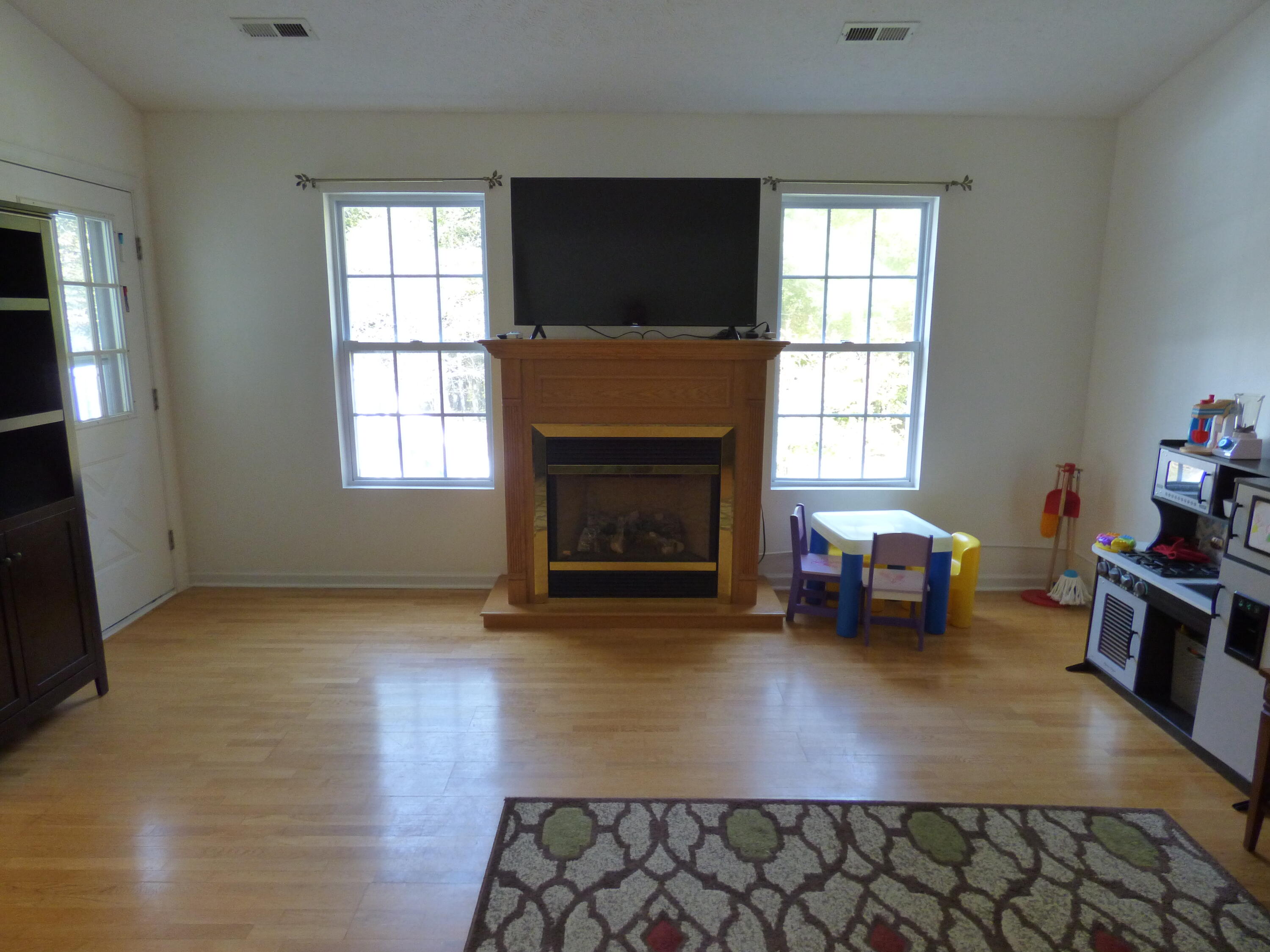110 Little Cabin Road Northeast Floyd, VA 24091 - Photo 25 of 32 an empty room with windows fireplace and wooden floor