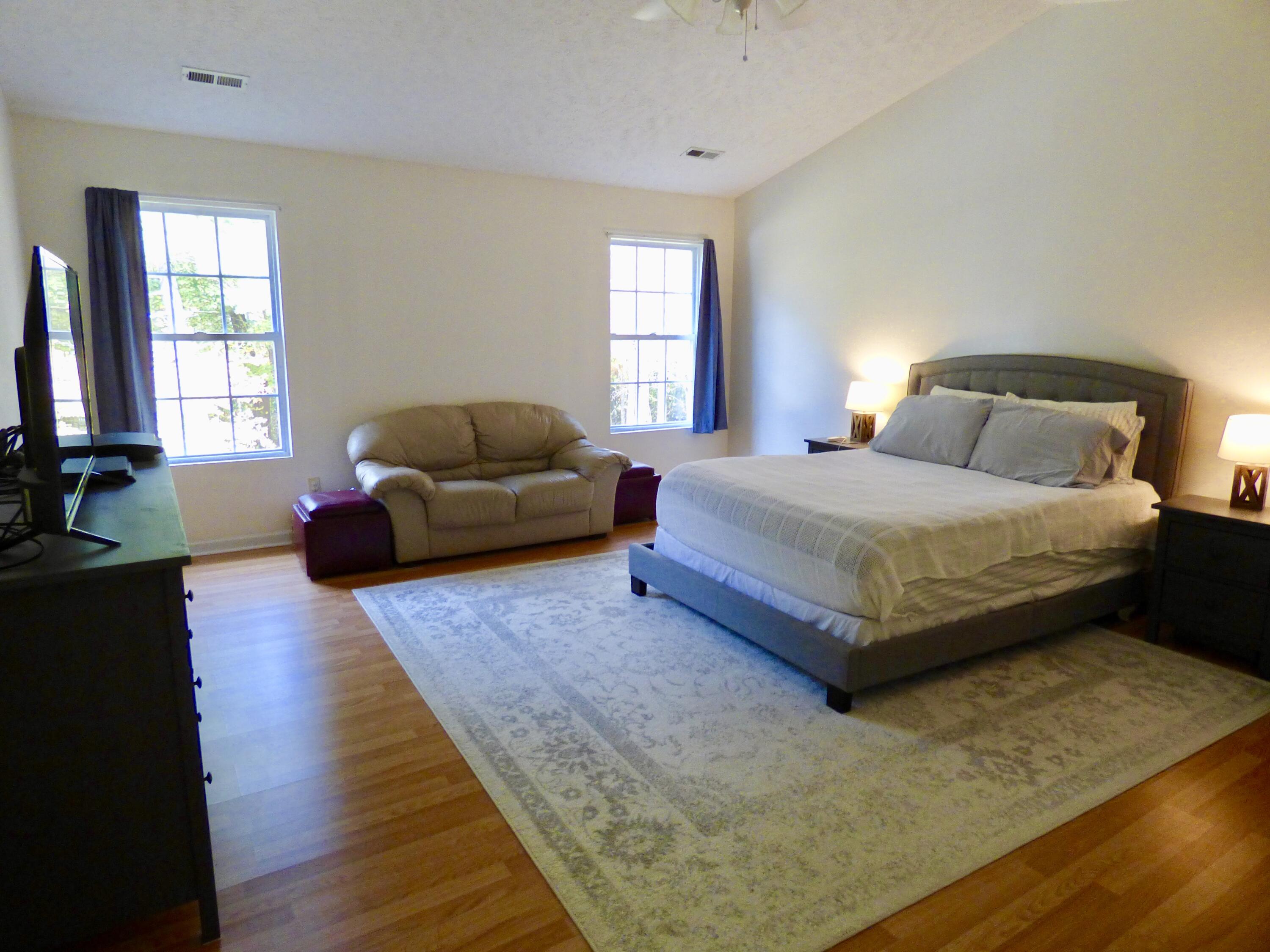 110 Little Cabin Road Northeast Floyd, VA 24091 - Photo 27 of 32 a bedroom with a bed couch and windows