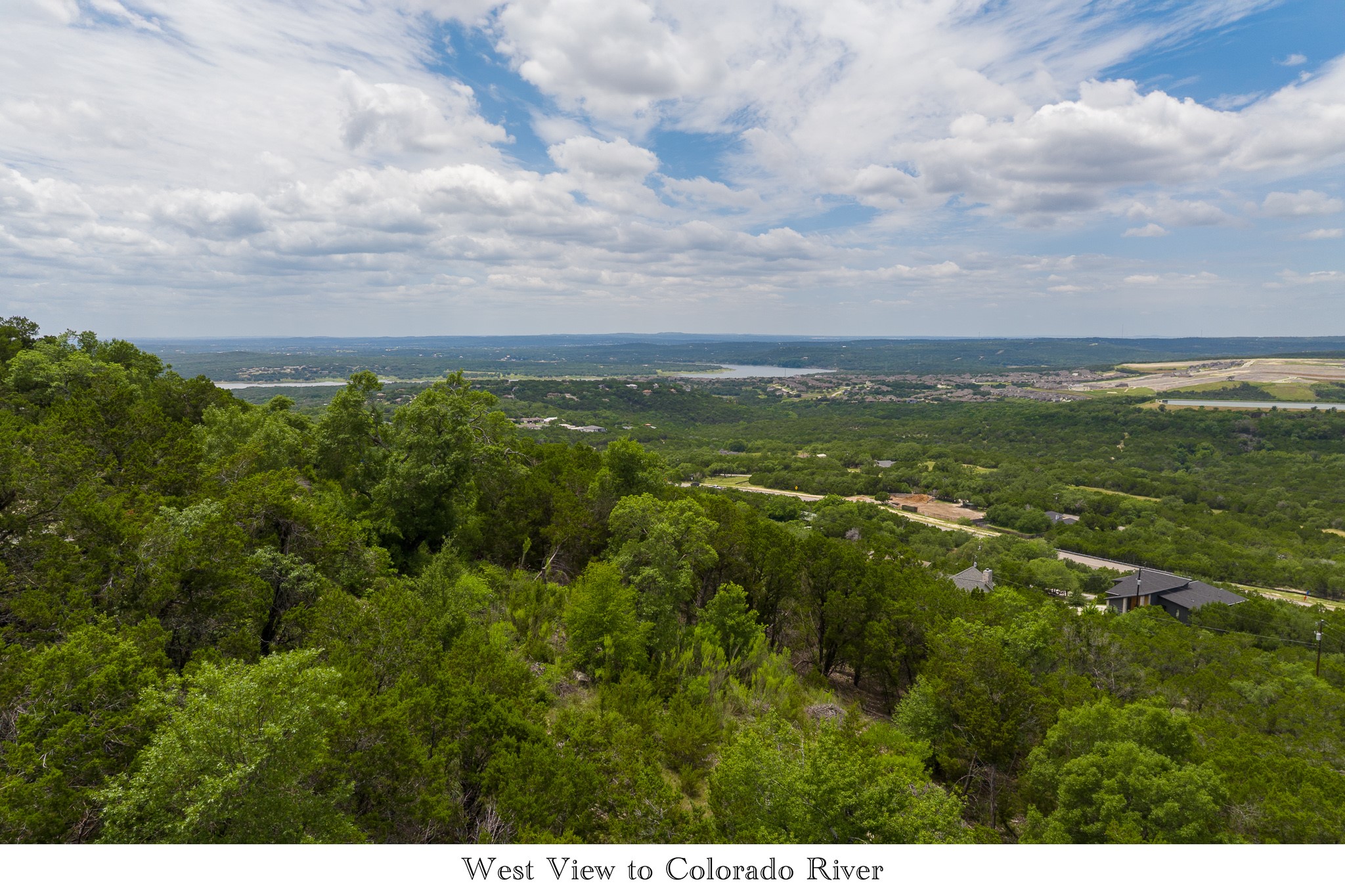 8220 Bar K Ranch Road Lago Vista, TX 78645 - Photo 5 of 8 Panoramic vista showcases verdant hillsides descending towards a distant river under an expansive sky.