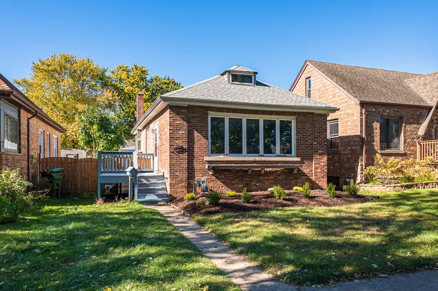 a view of a house with backyard and sitting area