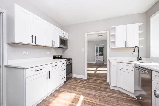 a kitchen with cabinets appliances and a sink