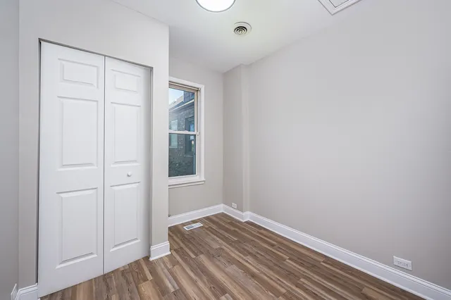 a view of a room with wooden floor and closet