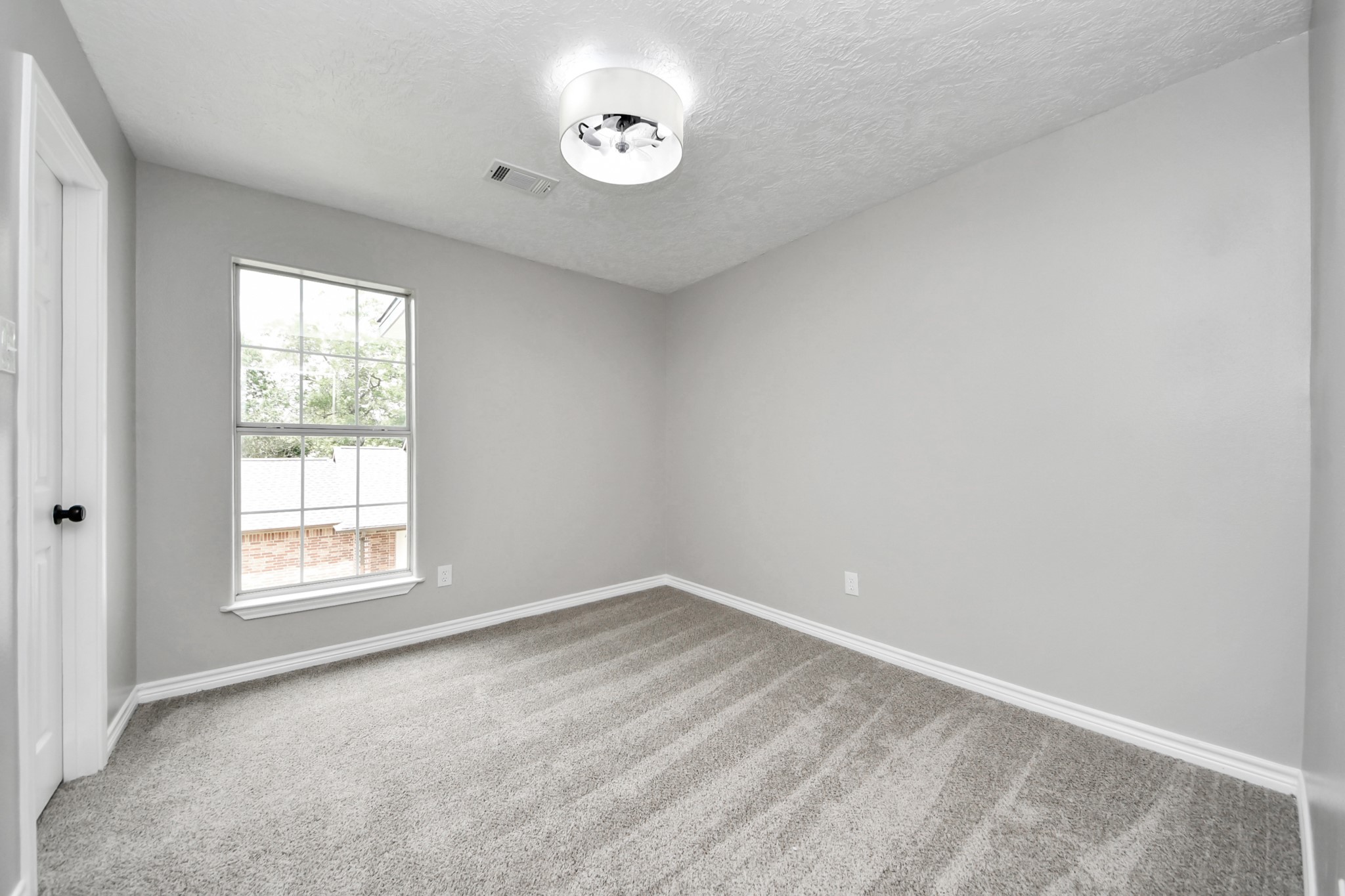 1105 East Kyle Road Clute, TX 77531 - Photo 31 of 44 This secondary bedroom has neutral gray walls, a plush carpet, and a large window providing natural light. The ceiling has a modern light fixture, and the space offers a cozy, clean feel, ideal for a bedroom or office.