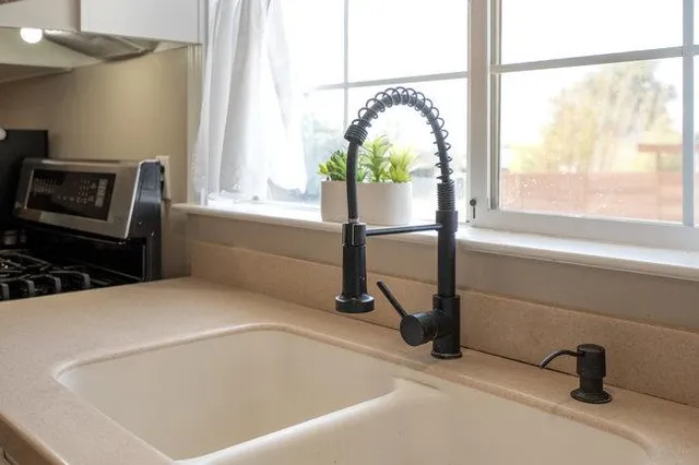 a kitchen with granite countertop white cabinets white appliances and a sink