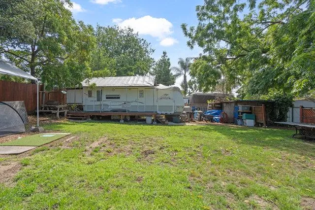 a view of a backyard with table and chairs under an umbrella