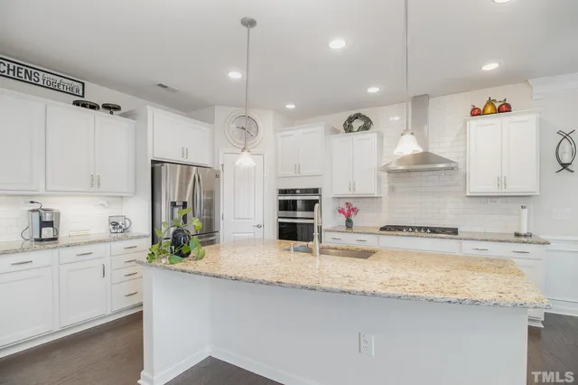 a kitchen with stainless steel appliances granite countertop a sink a stove and a refrigerator