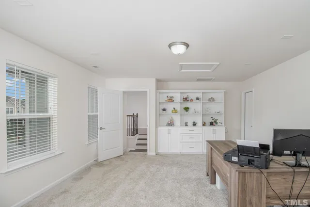 a view of a workspace with furniture and window