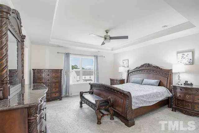 a spacious bedroom with a bed a couch and dresser