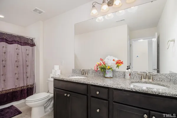 a bathroom with double vanity and a granite countertop