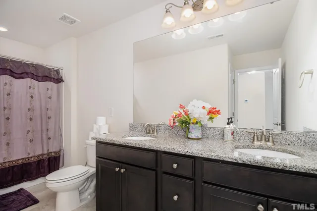 a bathroom with double vanity and a granite countertop