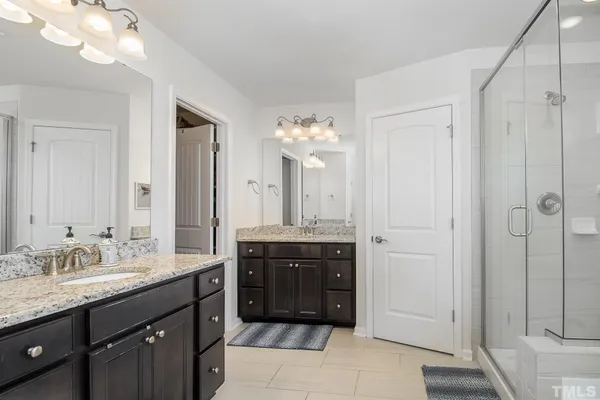 a spacious bathroom with a granite countertop sink a mirror and a bathtub