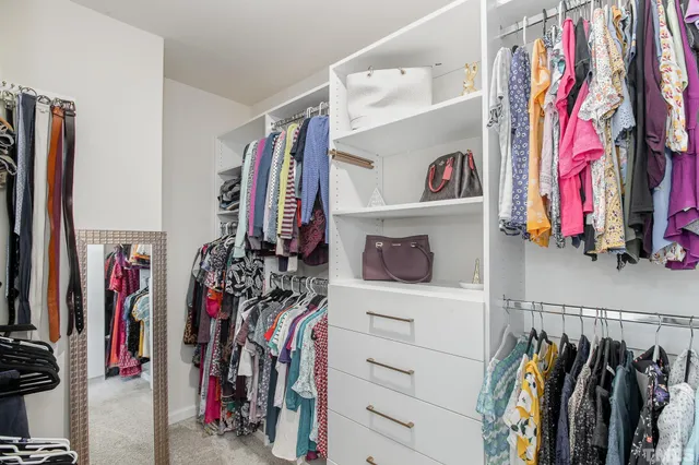 a view of walk in closet with clothes