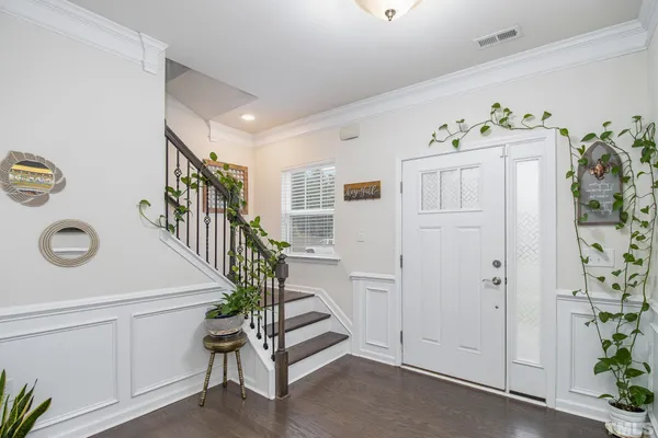 a hallway with white cabinets and wooden floor