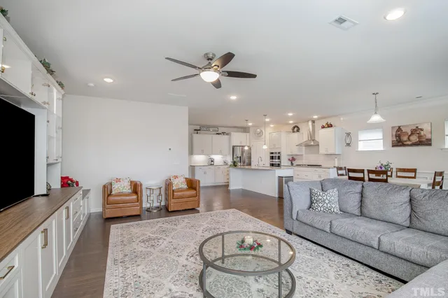 a living room with furniture a flat screen tv and kitchen view
